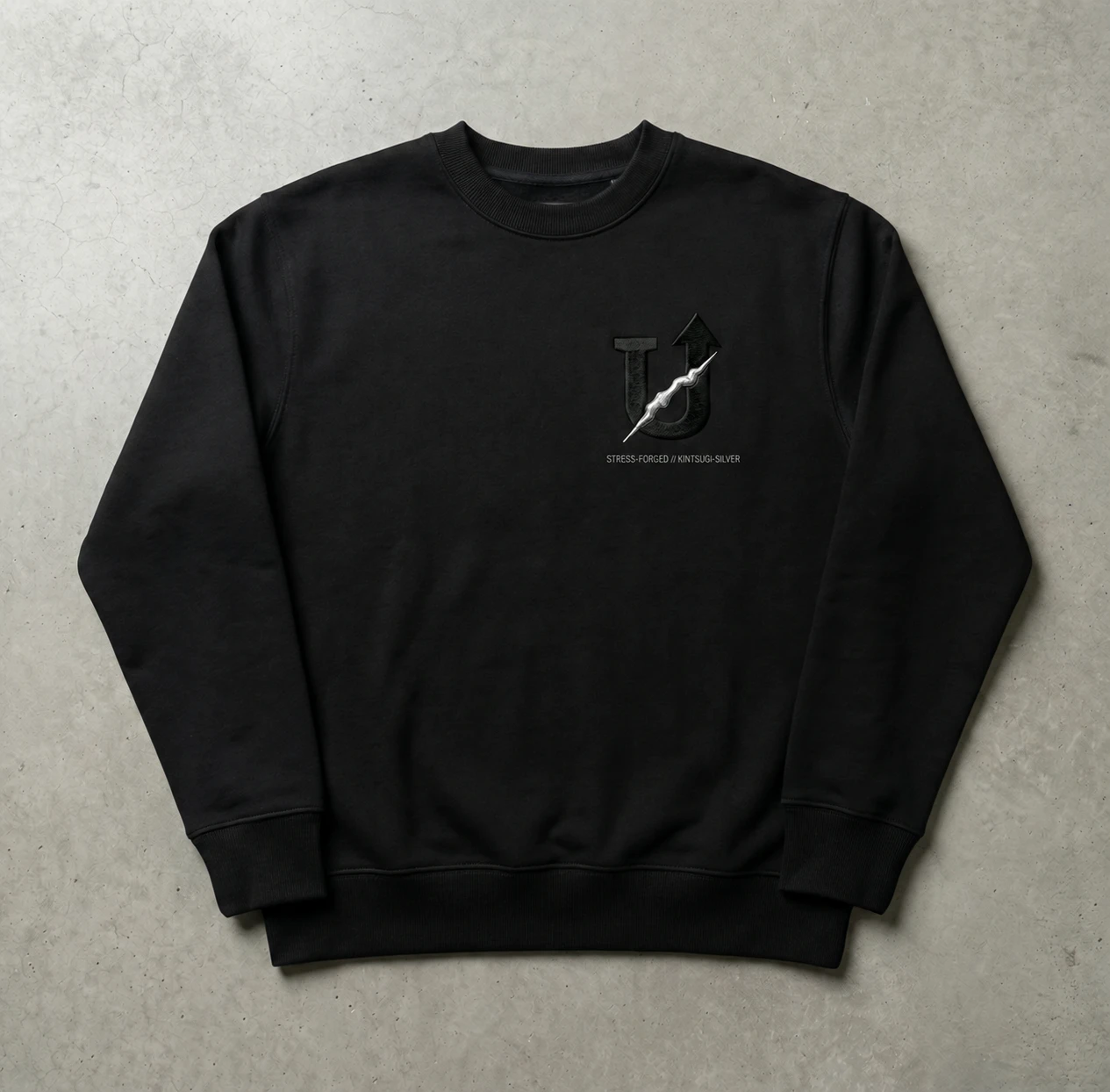 Concept study of a black crewneck sweatshirt with the silver-seam U-arrow at the left chest.